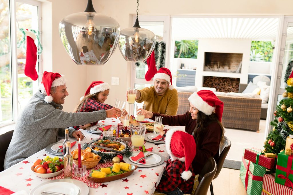 Caucasian multi generation family wearing santa hats having christmas meal