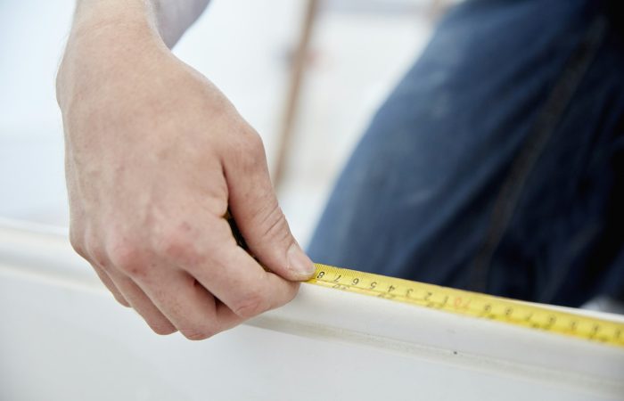 A man using a steel measuring tape.